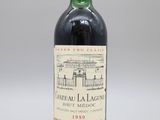 une bouteille de vin rouge posée sur une table blanche
