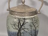 a glass jar with a lid that has a picture of a tree on it