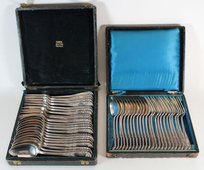 two open cases with silverware in them on a white surface