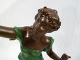 une statue représentant une femme tenant une raquette de tennis