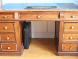 a wooden desk with drawers and a laptop on top of it