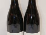 deux bouteilles de vin posées sur une table l'une à côté de l'autre