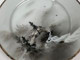 a white plate with a black and white painting on it