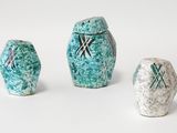 trois vases en céramique décorés, posés sur une surface blanche