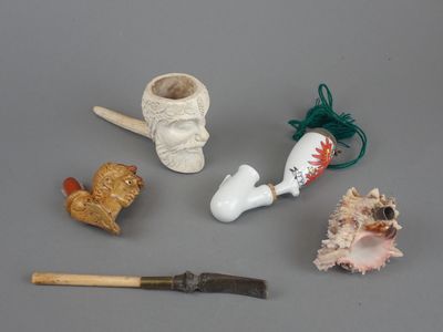 une petite collection d'objets miniatures comprenant une pipe, un poisson, un coquillage et un pinceau