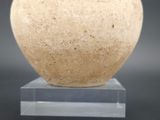 a vase that is sitting on a stand on a table