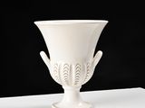 a white vase sitting on top of a white table