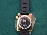 a close up of a watch on a green surface