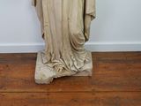a statue of a woman standing on a wooden floor