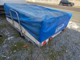 a blue tarp covering a trailer on the side of the road