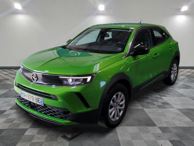the green suv is parked on a checkered floor in a garage
