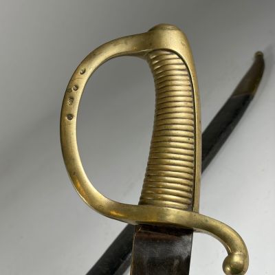 un gros plan d'une épée à la poignée dorée