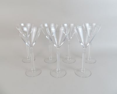 six verres à vin transparents sont alignés sur une surface blanche