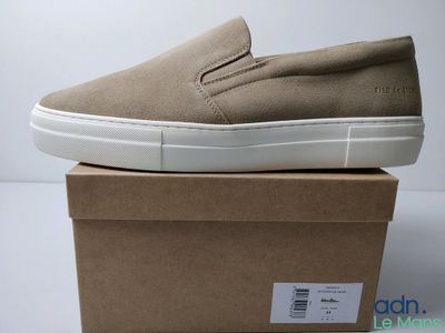 baskets slip-on pour homme, couleur beige, posées sur une boîte en carton