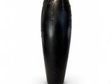 a black vase that is sitting on a white surface
