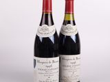 deux bouteilles de vin rouge posées l'une à côté de l'autre sur une surface blanche