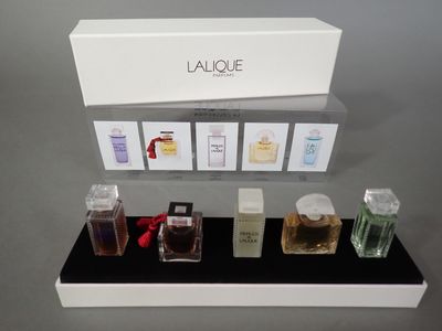 a display of various perfumes on a black shelf