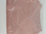 a pink sweater in a plastic bag on a table