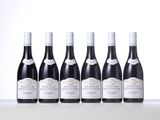 six bottles of wine are lined up in a row on a table