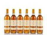 four bottles of wine are lined up on a white surface