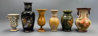 cinq vases alignés sur une surface grise