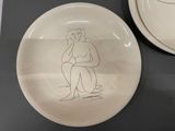 a white plate with a drawing of a woman on it