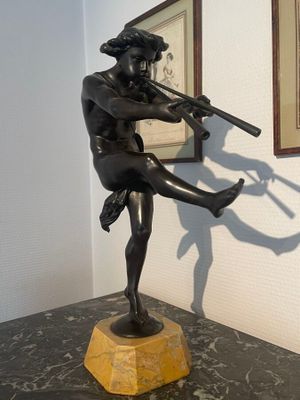 statue of a man holding a rifle in a room with a framed picture on the wall