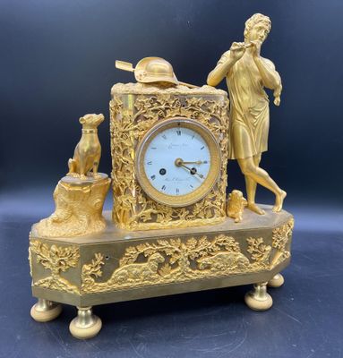 une horloge en or sur laquelle figurent un homme et une femme