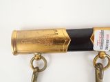 two keys attached to a brass pipe on a white surface