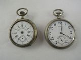 two silver pocket watches sitting on a white surface