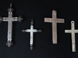 three silver and white crosses are on a black surface