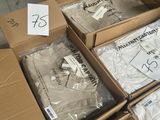 Plusieurs cartons de t-shirts blancs sont empilés les uns sur les autres