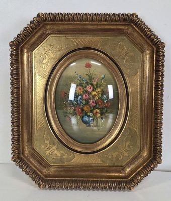 tableau représentant un vase de fleurs dans un cadre doré, accroché à un mur blanc