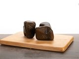 two pieces of wood sitting on top of a cutting board