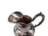 a silver pitcher with a handle on a white background