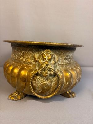 un pot en or orné d'un lion, posé sur une table