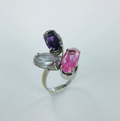 une bague en argent ornée de trois pierres de couleurs différentes