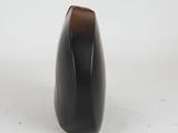 a black vase that is sitting on a white surface
