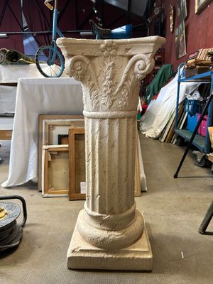 a white pedestal with a bird on top of it