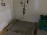 an image of a room with a scale and a trash can