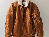 an image of a brown jacket hanging on a white wall