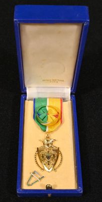une médaille dans une boîte bleue posée sur une surface noire