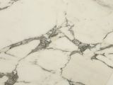 a close up of a marble table top with a clock on it