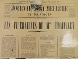newspapers are displayed on a wall in a store window