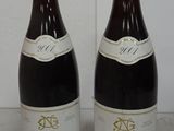 two bottles of wine sitting next to each other on a table