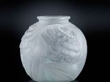vase en verre blanc posé sur une surface noire, avec un fond noir