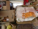 une pile de cartons contenant des vêtements et d'autres objets dans une pièce