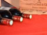 several bottles of wine are lined up on a red table cloth