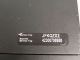 a close up of a black laptop with a service tag on it