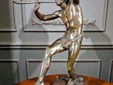 statue en bronze représentant un homme tenant un arc et une flèche, posée sur une table en bois